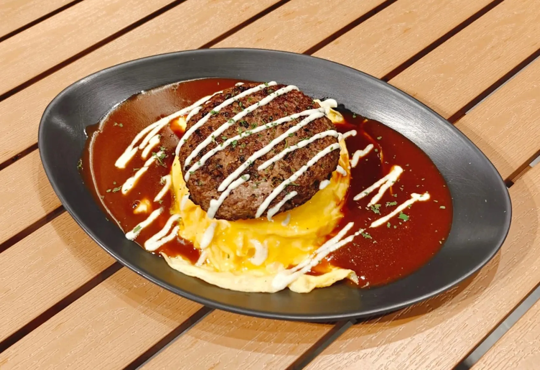 Beef Hamburg OmuRice — tornado omelette under an Angus beef patty, demi-glace and white sauce